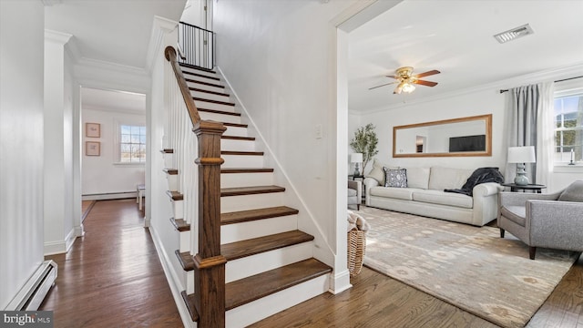 staircase featuring visible vents, crown molding, and baseboard heating