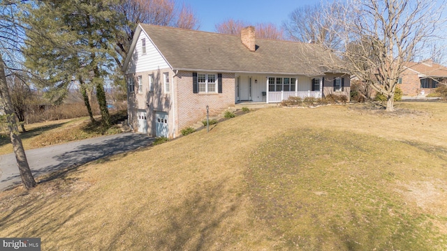 view of front of property featuring a garage, driveway, a chimney, a porch, and brick siding