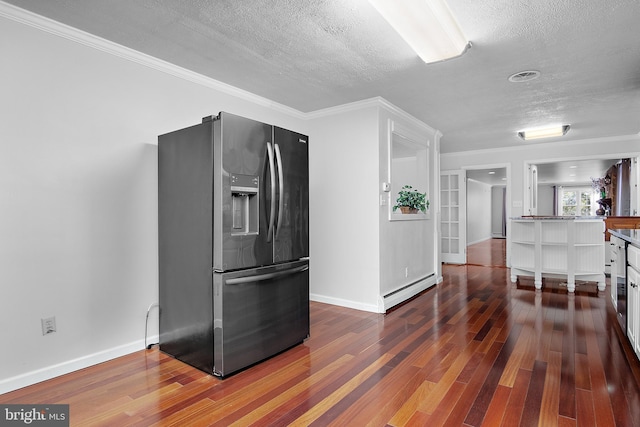 kitchen with a textured ceiling, a baseboard heating unit, wood finished floors, baseboards, and stainless steel fridge