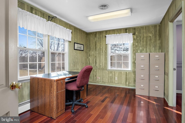 office space with a baseboard heating unit, visible vents, a wealth of natural light, and wood finished floors