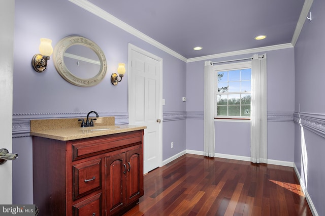 bathroom with baseboards, ornamental molding, wood finished floors, and vanity