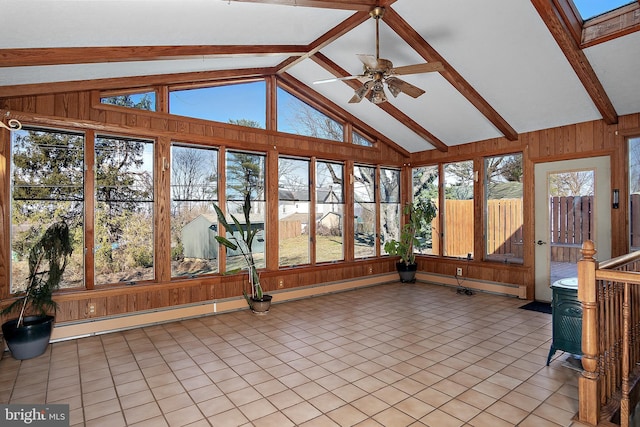 unfurnished sunroom featuring a wood stove, lofted ceiling with skylight, and a ceiling fan