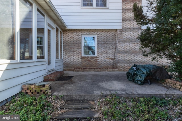 view of property exterior with a patio area and brick siding