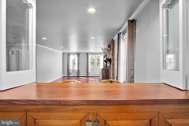 kitchen with ornamental molding, recessed lighting, brown cabinetry, and wood finished floors