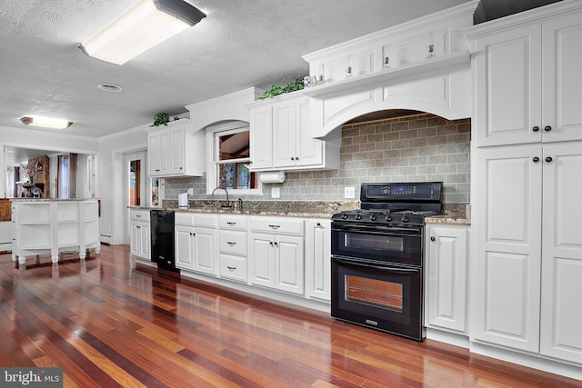 kitchen with dark wood-style floors, white cabinetry, backsplash, and black appliances