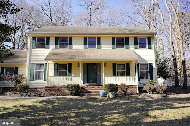 colonial inspired home featuring a porch and a front yard