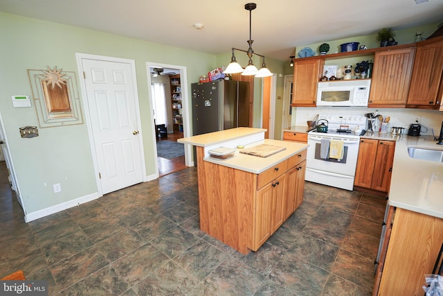 kitchen featuring white appliances, a sink, a center island, light countertops, and decorative backsplash