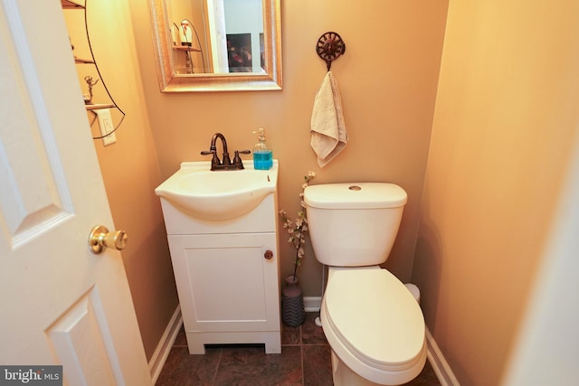 bathroom featuring baseboards, vanity, and toilet