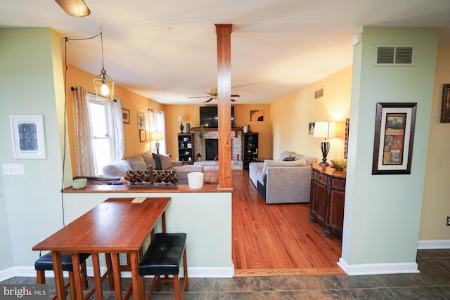 kitchen featuring pendant lighting, a fireplace, visible vents, and a ceiling fan