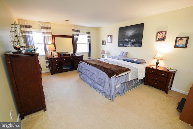 bedroom featuring baseboards and light colored carpet