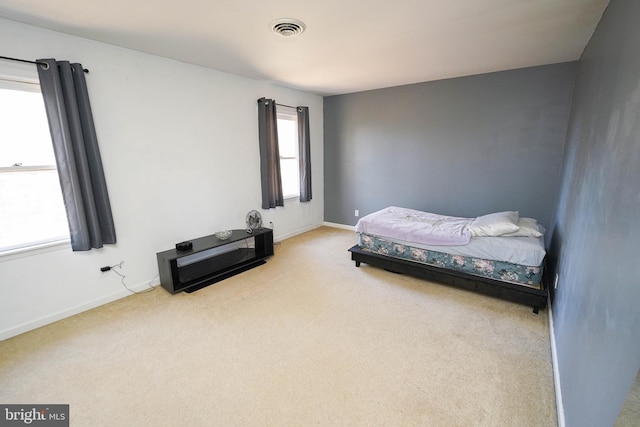 carpeted bedroom featuring baseboards and visible vents