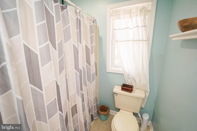 full bathroom featuring toilet, a shower with curtain, tile patterned flooring, and baseboards