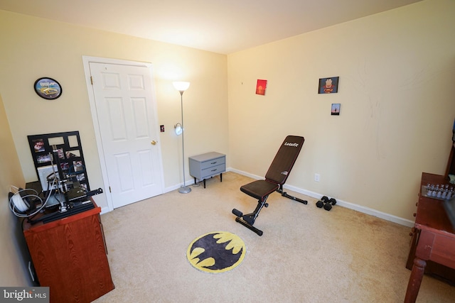 exercise area featuring carpet flooring and baseboards