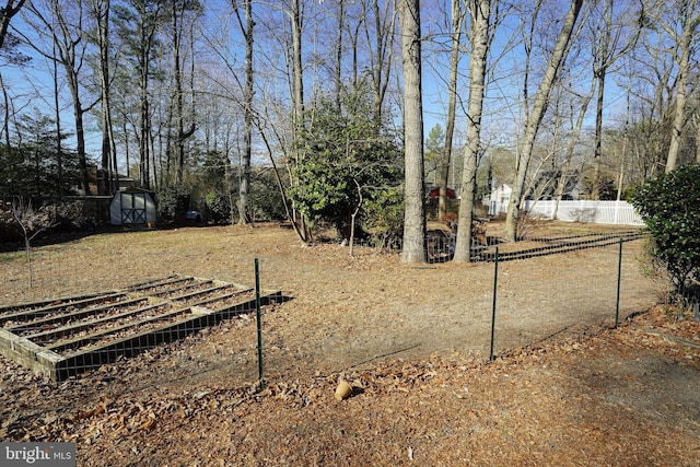 view of yard with an outbuilding, fence, and a shed