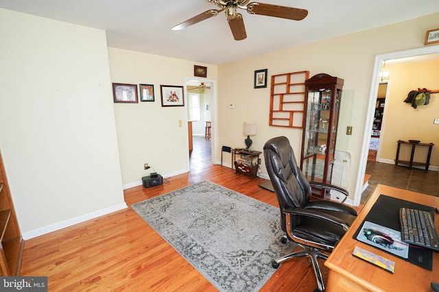 office area featuring ceiling fan, wood finished floors, and baseboards