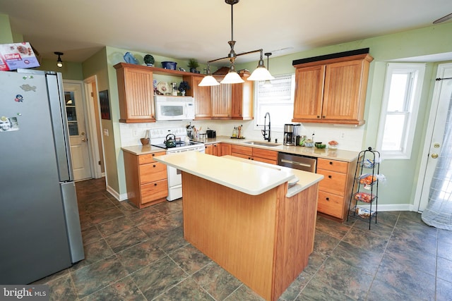 kitchen featuring baseboards, appliances with stainless steel finishes, a sink, light countertops, and backsplash