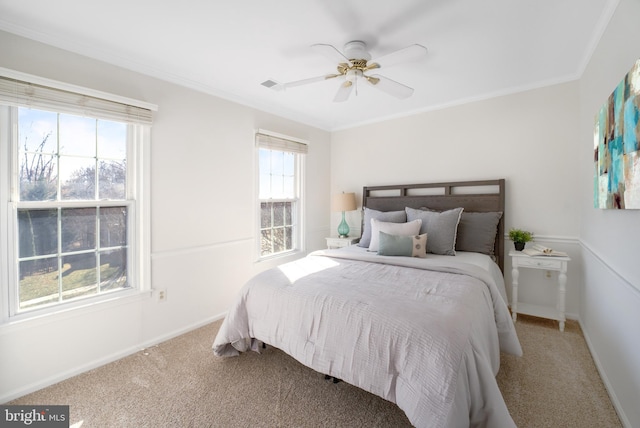 bedroom with a ceiling fan, baseboards, visible vents, carpet floors, and crown molding