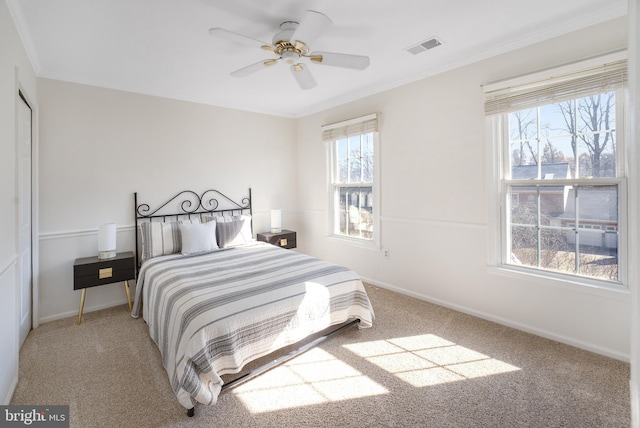 bedroom with visible vents, crown molding, baseboards, and carpet floors