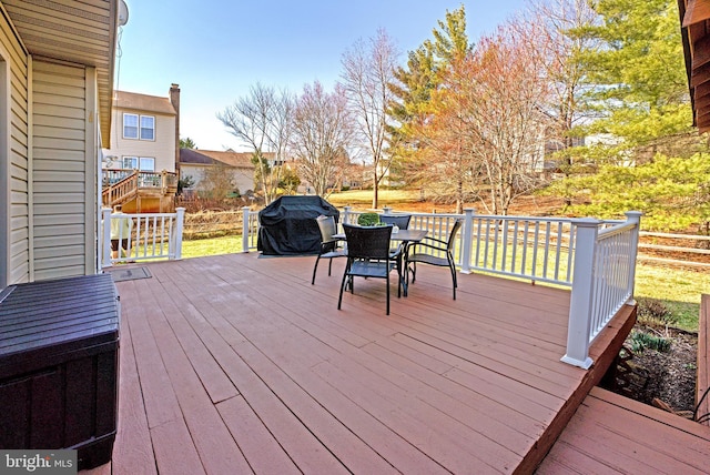 wooden terrace with outdoor dining space and a grill