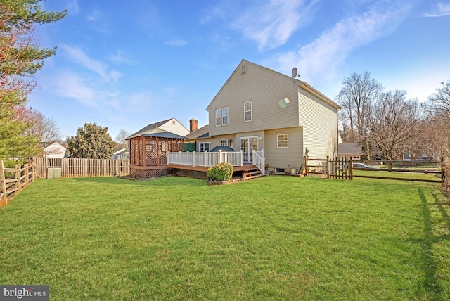 rear view of property with a wooden deck, a yard, and a fenced backyard