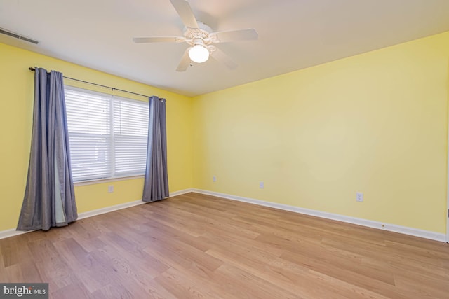 unfurnished room with visible vents, ceiling fan, light wood-type flooring, and baseboards