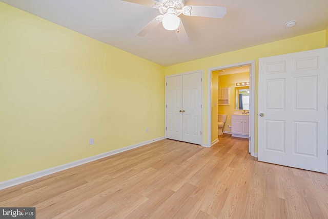 unfurnished bedroom with light wood finished floors, baseboards, ensuite bathroom, a closet, and a ceiling fan