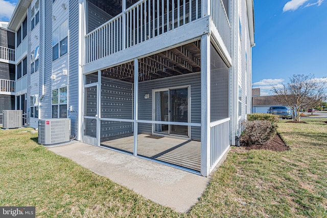 exterior space with central air condition unit and a yard