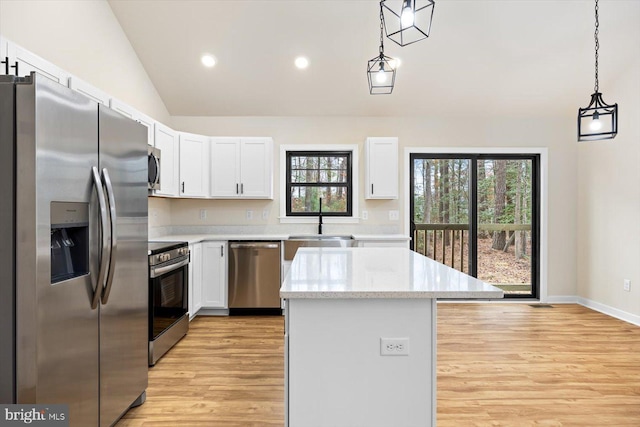 kitchen with a center island, pendant lighting, appliances with stainless steel finishes, white cabinetry, and a sink