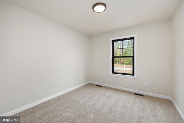 unfurnished room with carpet floors, baseboards, and visible vents