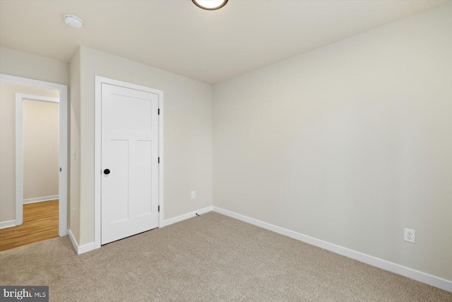 unfurnished bedroom featuring baseboards and light colored carpet