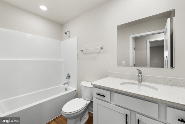 full bathroom featuring toilet, recessed lighting, wood finished floors, vanity, and  shower combination