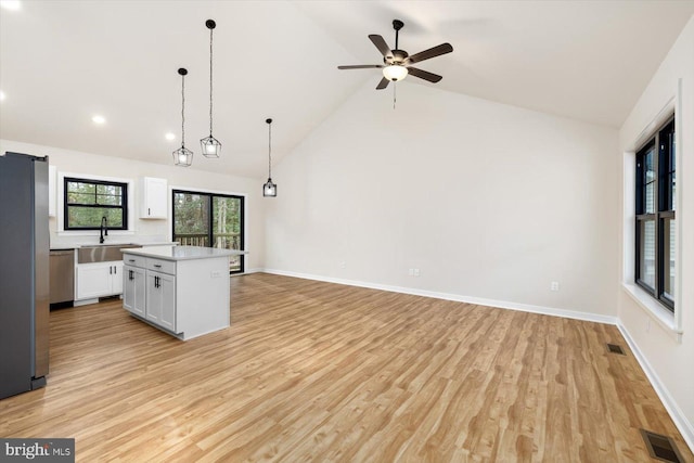 kitchen featuring white cabinetry, visible vents, stainless steel appliances, and a center island