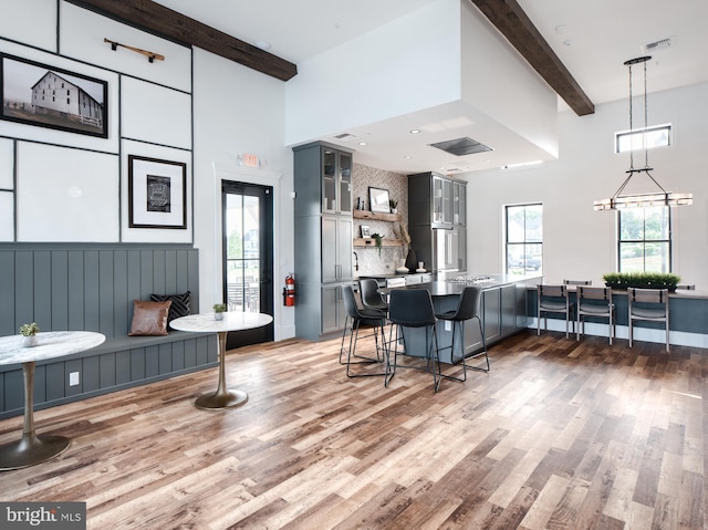 interior space with beamed ceiling, a breakfast bar area, and gray cabinetry