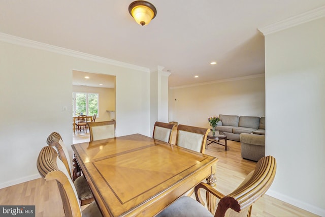 dining space featuring recessed lighting, crown molding, light wood-style flooring, and baseboards