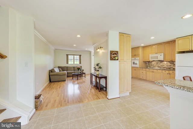 kitchen with crown molding, light tile patterned floors, tasteful backsplash, light brown cabinets, and white appliances