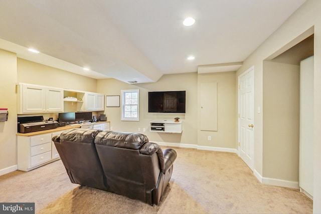 living room featuring recessed lighting, light colored carpet, visible vents, built in study area, and baseboards