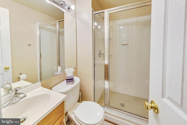 bathroom with toilet, a stall shower, and vanity