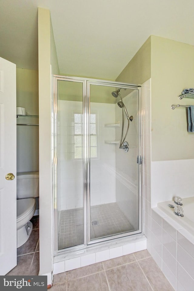 bathroom with toilet, a stall shower, a garden tub, and tile patterned floors