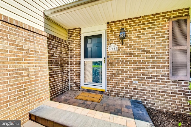 doorway to property featuring brick siding