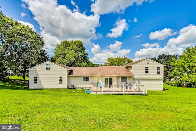 rear view of house featuring a wooden deck and a yard