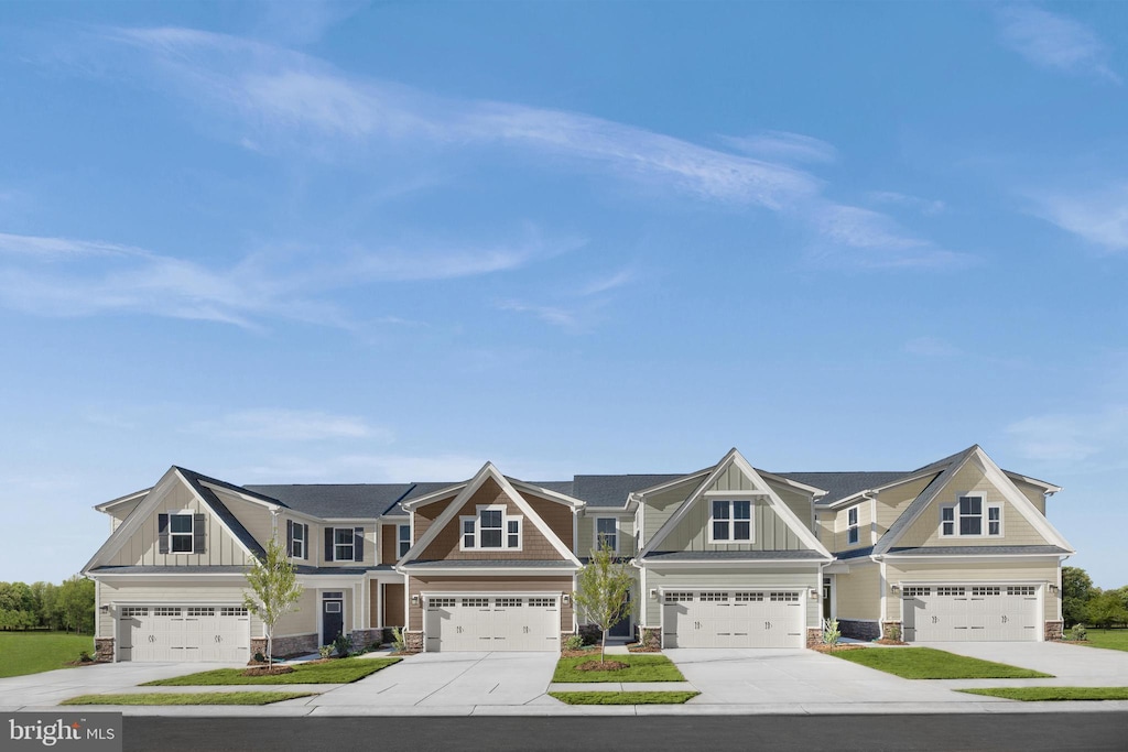 view of front facade with driveway, board and batten siding, stone siding, and a residential view