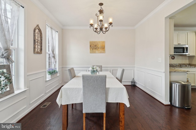 dining room featuring an inviting chandelier, crown molding, visible vents, and dark wood-style flooring