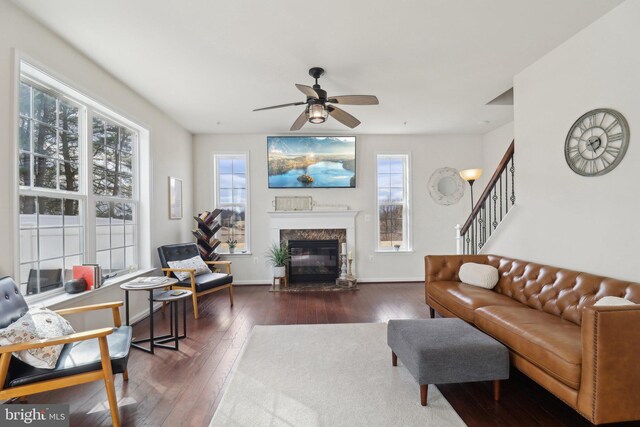 living area with stairs, hardwood / wood-style floors, a wealth of natural light, and baseboards