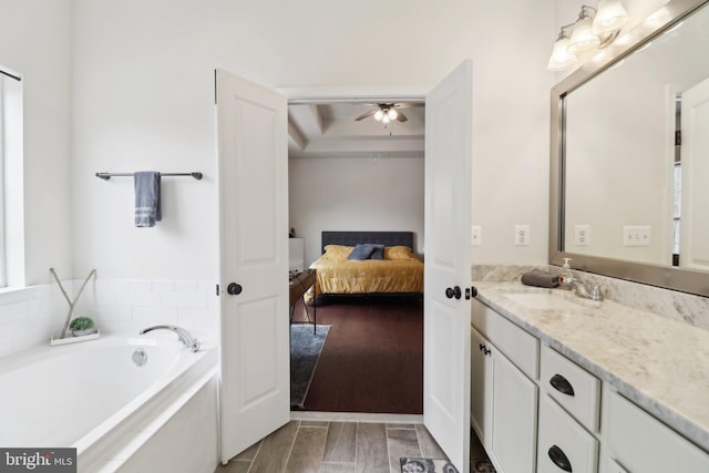 ensuite bathroom with a garden tub, ensuite bathroom, a ceiling fan, vanity, and wood finished floors