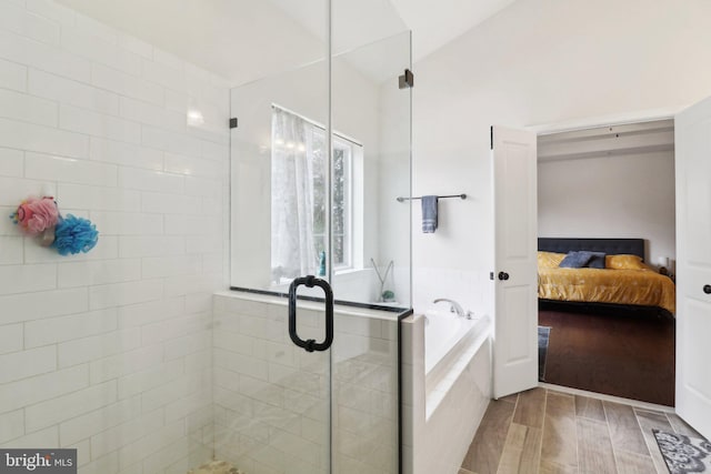 ensuite bathroom with ensuite bathroom, a garden tub, wood finished floors, vaulted ceiling, and a stall shower