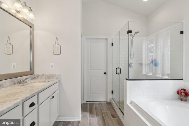 full bath featuring vanity, baseboards, a shower stall, a bath, and wood tiled floor