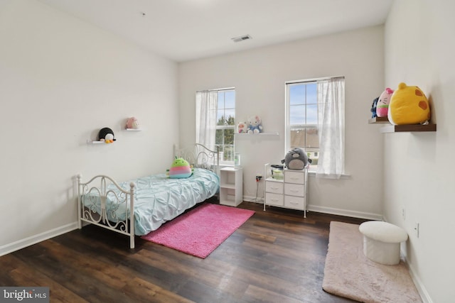 bedroom featuring baseboards, visible vents, and wood finished floors