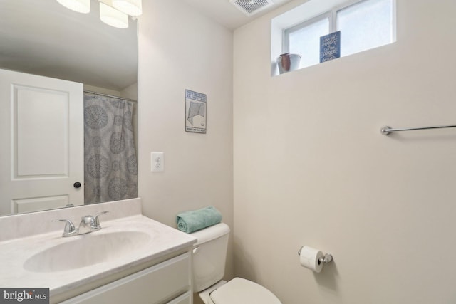 full bath with toilet, visible vents, and vanity