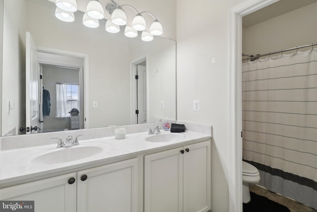 full bath with double vanity, toilet, a sink, and tile patterned floors