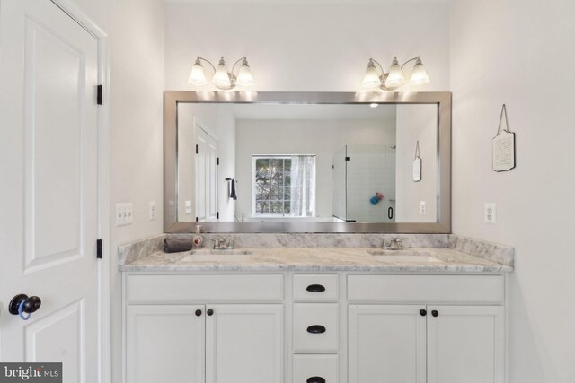 full bath with double vanity, a stall shower, and a sink